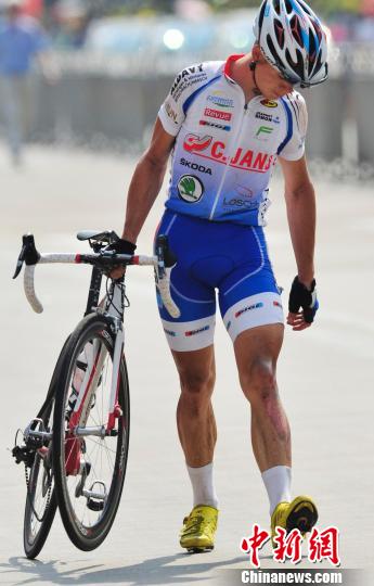 图为受伤的卢森堡迪弗丹热洲际队106号选手塞缀克·加瓦抬着摔坏的自行车走向终点。 骆云飞 摄