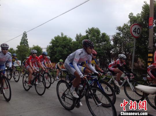 图为2013年环崇明岛女子国际公路自行车赛在沪举行,选手在激烈争夺中 宗晨亮 摄