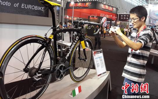 一位骑行爱好者在环法冠军公路车前拍照　齐书懿　摄