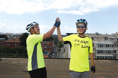 父子俩击掌相互鼓励。今天,李近赫要带儿子小时沿京杭大运河骑行,历时20天,行程约1800公里。新京报记者 高玮 摄